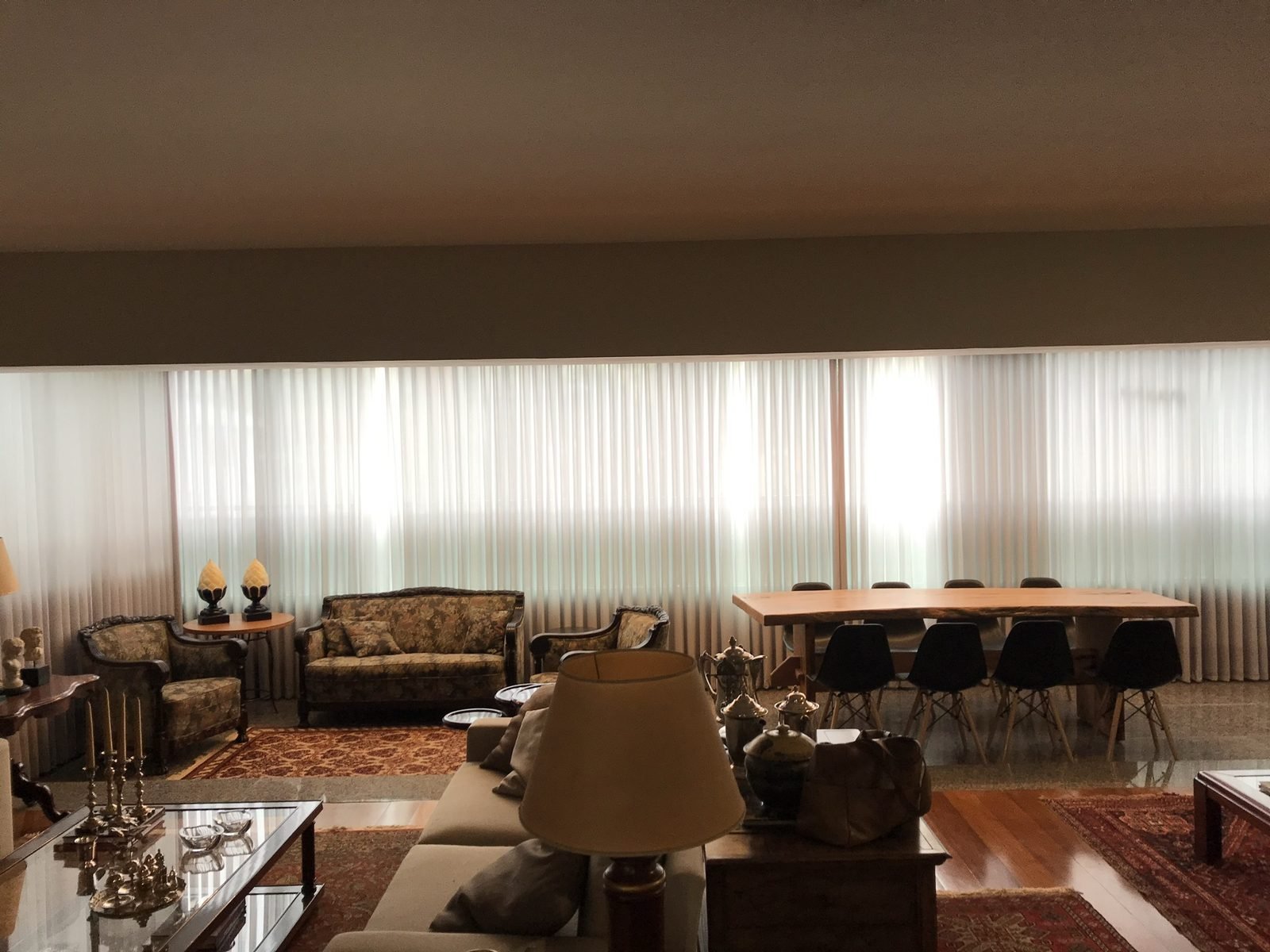 Ambiente integrado de estar e jantar com cortinas wave claras ao fundo